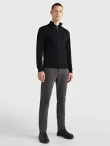 Cárdigan Tommy Hilfiger de color negro confeccionado en una mezcla de algodón pima orgánico y cachemira. Presenta un diseño con cierre de cremallera frontal, cuello levantado de punto canalé y el logo de la marca bordado en el pecho.