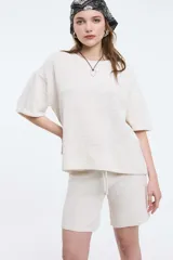 Top de tejido de punto color marrón, con cuello redondo y mangas cortas de corte holgado.