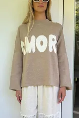 Sweater de tejido de punto color azul marino, con cuello alto y manga larga. Presenta la palabra "AMORE" estampada en el frente en letras grandes de color blanco.