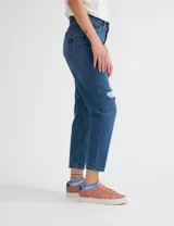 Pantalón de jean azul de corte mom con roturas en las rodillas.