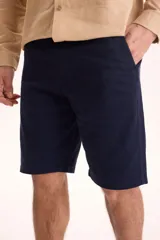 Bermuda estilo chino confeccionada en gabardina de color azul marino, con bolsillos laterales y traseros, de corte recto y largo hasta las rodillas.
