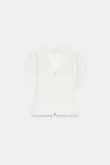 Top de Zara Woman Collection color blanco, con escote en pico, mangas cortas abullonadas con aberturas y cierre frontal con cremallera.