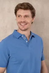 Chomba azul de piqué de algodón con cuello polo, tapeta de dos botones con diseño estampado en el interior y mangas cortas. Corte clásico.