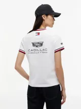 Remera de algodón Tommy Hilfiger en colaboración con Cadillac Formula 1 Team, de corte holgado y largo cropped. Presenta cuello redondo con ribetes tricolores, mangas cortas con ribetes a juego y cinta distintiva en los laterales. Incluye logos de Cadillac, Tommy Hilfiger y Pirelli estampados en el pecho y mangas.
