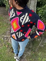 Sweater tejido de lana color azul marino con diseño geométrico en blanco.