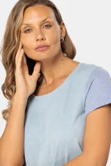 Remera de manga corta con cuello redondo y diseño de bloques de color. El cuerpo es beige, la manga izquierda es azul claro y la manga derecha es rosada.