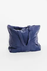 Bolso tipo tote bag color negro, con diseño acolchado y asas dobles.