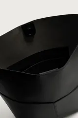 Bolso tipo shopper de diseño minimalista en color negro, con dos bolsillos planos exteriores y compartimento principal con cierre magnético. Incluye un bolsillo interior y asa de hombro ajustable.