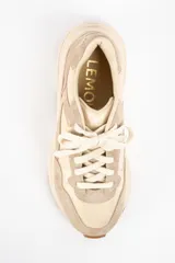 Zapatilla urbana de diseño chunky, confeccionada en una combinación de cuero liso y gamuza en tonos beige y arena. Presenta cordones al tono, suela de plataforma con relieve y detalle de marca grabado en el talón.