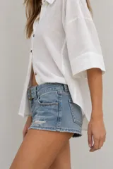 Camisa de lino blanca oversize, con cuello solapa, mangas anchas y cierre frontal con botones.