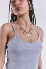 Musculosa corta gris de morley con breteles finos y terminación ondulada en el ruedo.