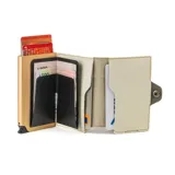 Billetera tarjetero automática con estructura de aluminio y revestimiento de cuero bicolor en tonos verde oliva y beige. Cuenta con un cierre de broche a presión y el logo de la marca grabado en la parte inferior.
