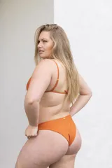 Conjunto de bikini color naranja con corpiño triangular de tirantes finos y bombacha clásica.