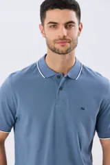 Remera polo de piqué manga corta, color celeste, con cierre frontal de botones y detalles de vivo en contraste blanco en el cuello y los puños.