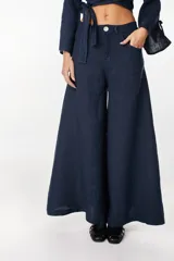 Pantalón azul marino de lino con diseño wide leg, tiro medio y bolsillos delanteros.