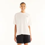 Remera New Balance de manga corta y corte oversize, color blanco, con pequeño estampado gráfico en el pecho.