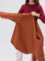 Campera reversible capitoneada con cierre frontal. Un lado es de color negro y el otro es de color beige, ambos con diseño acolchado. Cuenta con cuello redondo, mangas largas y bolsillos laterales.