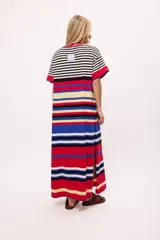 Vestido largo tejido a rayas horizontales en tonos beige, marrón, negro y rojo. Tiene cuello redondo, mangas cortas y tajos laterales.