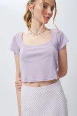 Top corto negro de escote cuadrado y manga corta con costuras tipo corsé.