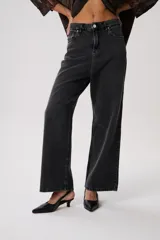 Jean baggy de tiro medio en denim negro con efecto lavado. Cuenta con una estructura relajada, pierna ancha y costuras visibles.