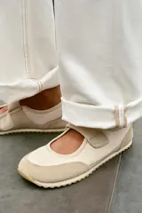 Bailarina deportiva tipo barefoot en color beige, con puntera amplia, cierre de velcro en el empeine, detalles en gamuza y suela flexible de goma.