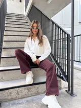 Buzo de cuello polo con cierre frontal parcial, de corte holgado y mangas largas con puños ajustados.