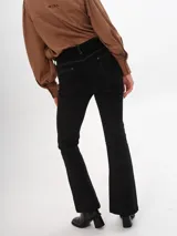Pantalon de pana color marrón, de corte ajustado con costuras verticales frontales y tajos en el ruedo.