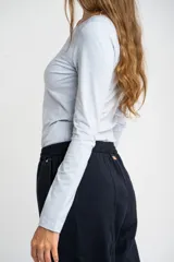 Remera de manga larga ajustada al cuerpo, con cuello redondo, confeccionada en una mezcla de algodón y elastano que aporta suavidad y elasticidad.