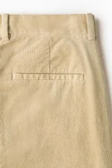 Pantalón de pana de corte regular fit, color beige, con cierre de botón y cremallera, bolsillos laterales y trabillas para cinturón.