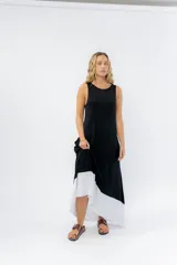 Vestido largo negro con base blanca, de corte suelto y sin mangas.