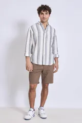 Camisa de corte regular con diseño de rayas verticales finas en tonos claros, cuello clásico y mangas largas con puños abotonados.