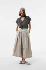 Pantalón wide leg de color blanco, de silueta amplia y gran movimiento, con pliegues delanteros que aportan volumen y estructura, y cintura definida.