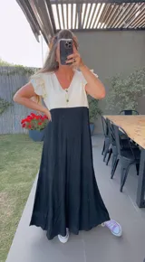 Vestido largo de morley combinado en dos tonos, con mangas cortas con volados y botones decorativos.