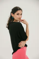 Remera negra de corte holgado con estampado de hojas de colores en el frente.