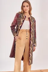 Saco largo abierto con diseño estampado estilo paisley y motivos florales en tonos bordó, negro y beige. Presenta un corte recto y mangas largas.