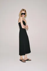 Vestido midi negro confeccionado en mezcla de viscosa, con escote palabra de honor, hombros descubiertos, corte evasé y cierre lateral con cremallera oculta.