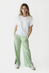 Pantalón negro de tiro alto, con tajo en el costado y pierna ancha.