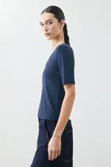 Remera de punto con acabado brillante, cuello en V y mangas cortas.