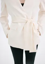 Blazer Martin de diseño recto y color beige, con cuello en pico, sin solapa, manga larga y bolsillos frontales de parche. Incluye forro interior.