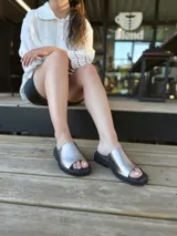 Sandalias chatas de cuero color peltre, fabricadas en Uruguay.