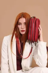 Bandolera de diseño rectangular con textura granulada, color verde oliva. Cuenta con tres compartimentos principales con cierre, un bolsillo frontal adicional y correa ancha ajustable de tela en tono a juego.