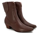 Bota corta de cuero color marrón, con taco cuadrado y punta fina. Presenta una correa con tachas pequeñas y una argolla metálica decorativa alrededor del tobillo. Cuenta con cierre lateral.