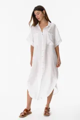 Camisola larga blanca de lino con botones de nácar y bolsillos delanteros.