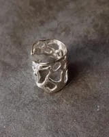 Anillo ancho de diseño orgánico y calado, con apariencia de red o magma solidificado.