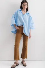 Camisa marrón con cuello clásico, abotonada al frente y mangas 3/4 abullonadas.