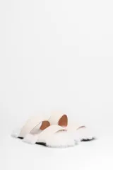 Sandalias bajas con dos tiras anchas de cuero sintético color crema y base forrada en piel sintética blanca.