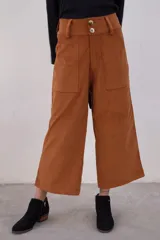 Pantalón marrón de pana con corte cropped y bolsillos frontales.