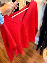 Remera de algodón color rojo con escote en V, mangas largas y diseño holgado. Presenta una costura vertical central en el frente.