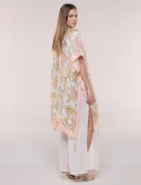 Kimono de gasa ligera con estampado floral en tonos beige y salmón, de silueta amplia, mangas cortas integradas y ruedo asimétrico con detalles de borlas en las puntas.