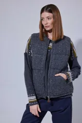 Chaleco tejido de punto color marrón con cuello de piel sintética, cierre frontal con cursor de cuero y diseño acolchado con cortes horizontales.